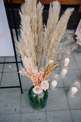 decor of the wedding ceremony area with fresh flowers and pampas grass