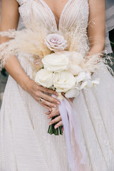 bride holds a beautiful wedding bouquet in white