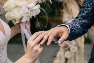 bride and groom exchange rings at a wedding ceremony