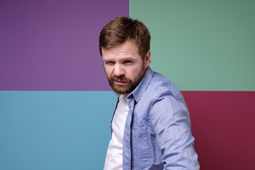 Angry, dangerous bearded man with a impudent squint.