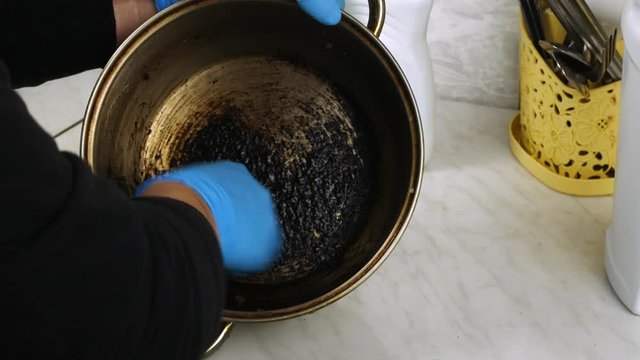 Clean With A Wire Brush The Burnt Pan.Cleaning In The Home Kitchen.