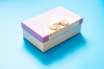 cardboard gift box in purple color scheme with a bow on a blue background