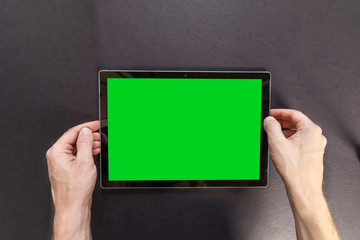 A person’s hands holding digital tablet with blank copy space screen for your text message or promotional content, Isolated on black