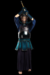 Naklejka premium Portrait of man kendo fighter with shinai (bamboo sword). Shot in studio. Isolated with clipping path on black background