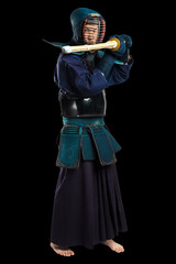 Portrait of man kendo fighter with shinai (bamboo sword). Shot in studio. Isolated with clipping path on black background