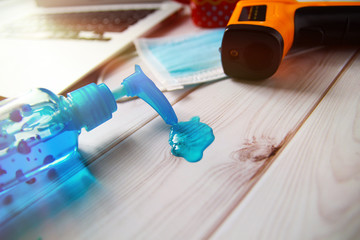 New normal with medical mask , hand sanitizer spray, Body thermometer, computer for work form home, and Covid-19 (Coronavirus) pandemic.