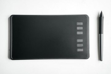 New graphics tablet and pen on a white table.