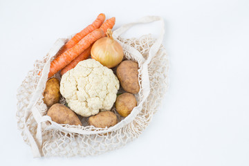 carrot, potato and cauliflower in a string bag
