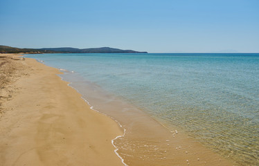 Fototapeta premium Beautiful sunny coast view to the greek mediterranean blue sea with crystal clear water and pure sandy beach empty place