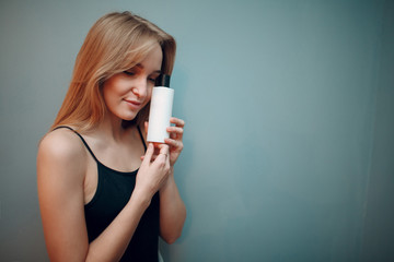 Pretty young woman with white bottle coscmetics with copy space