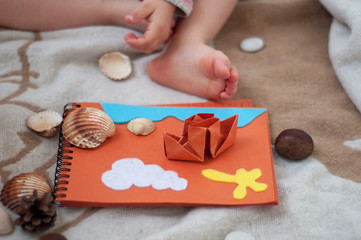 Soft felt toys on paper. Seashells and paper ship. Origami ship. Educational toys. Cute background. Home concept.