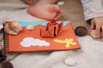 Soft felt toys on paper. Seashells and paper ship. Origami ship. Educational toys. Cute background. Home concept.