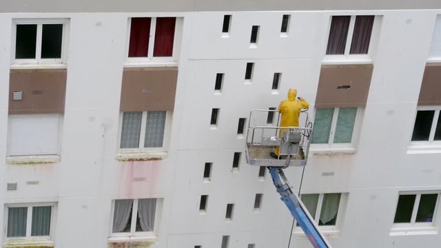 Homme utilisant un nettoyeur haute pression sur une nacelle