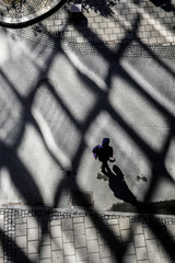 Stockholm, Sweden Silhouetted pedestrians walk among strong window shadows projected from a nearby building in the sun in the Globen section of town.