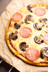 Freshly making pizza with mushrooms served on the rustic background. Selective focus. Shallow depth of field.
