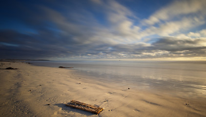 Plakat long exposure image of sandy beach and clouds