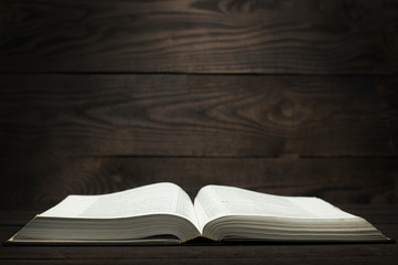 Open book bible. On wooden background