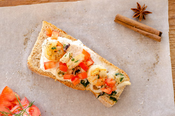 baguette with seafood tomato and cinnamon wooden cutboard background