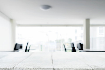 Fototapeta premium Desk space over blurred office or meeting room background. Product display.