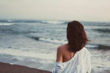 man on the beach with black sand and coastal wave sea ocean