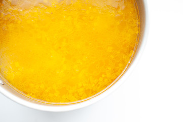 Closeup of broth, clear soup or bouillon in a saucepan top view