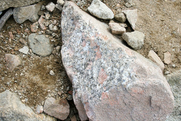 Stones lying on the ground in the mountains. Big boulder on the road.