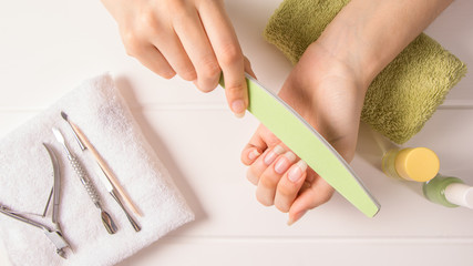 Manicure. A woman files her nails. Shorten long nails. Manicure tools. Home nail care, SPA, beauty....