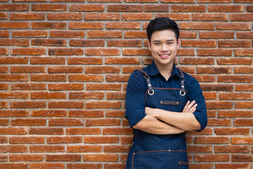 Startup asian young small business owner man standing front his coffee shop or restaurant. Portrait of successful young small business man barista cafe owner.