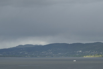 A fjord in Norway and a small boat sailing in.