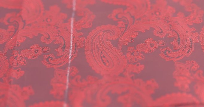 designer of clothes makes an outline of clothes with a felt-tip pen. male hands closeup. Fashion designer or tailor working with fabric at the studio full of tailoring tools.