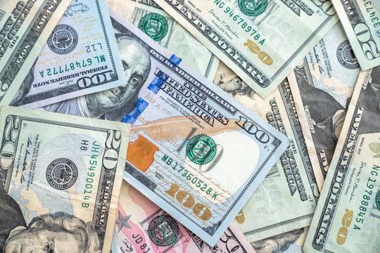 A background image closeup of american or united states paper currency or cash including hundred dollar bills, fifties and twenties making a great financial or economic backdrop wallpaper.