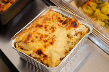 a container holding hot water into which a pan is placed for slow cooking pasticcio