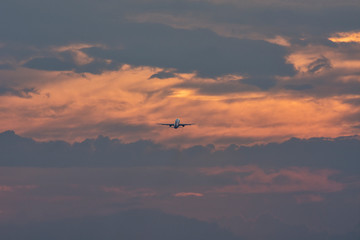 Taking off airplane at colorful sunset. Silhouette, selective focus. Landscape, background.