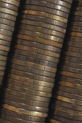 Background from stacks and edges of yellow brass coins placed at an angle diagonally across the image. 10 Russian rubles close up. Dark vertical backdrop or wallpaper on economic, banking topic. Macro