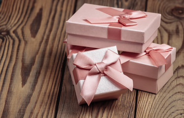 Gift boxes with bow on wooden background close-up