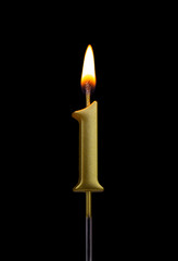 Burning birthday golden candle isolated on black background, number 1