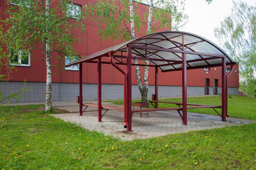 Construction of a metal gazebo with wooden benches.