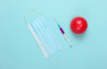 Coronavirus vaccine. Virus strain and syringe, face  mask on blue background. Vaccination. Medical...