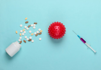 Coronavirus vaccine and treatment. Virus strain, syringe and pills on blue background. Vaccination....