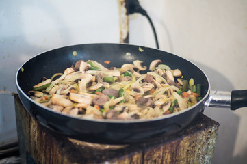 Cook at home. Homemade dish in a pan, stewed hearts with vegetables and mushrooms.