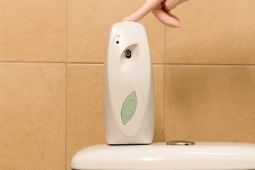 Automatic air freshener dispenser with a hand pressing a button