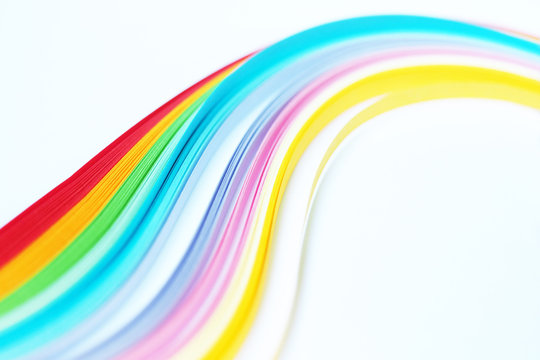 Colored strips of paper for quilling, rainbow stretches into the distance, selective focus