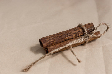 Cinnamon sticks tied with jute rope on beige paper.
Food concept