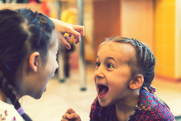 Two little sisters shouting. Selective focus. toned