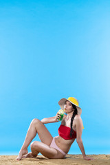 Teen sitting while sipping a cold alcoholic drink while enjoying the holiday sun.