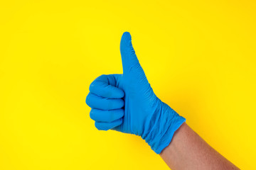 Hands in medical gloves showing thumbs up gesture. Medicine and healthcare concept
