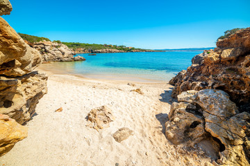 Fototapeta na wymiar Rocks and sand in a small cove in Sardinia