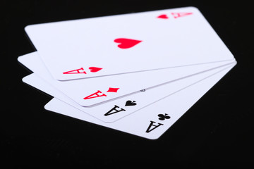 Playing cards of four aces on black background. Game addiction. Poker