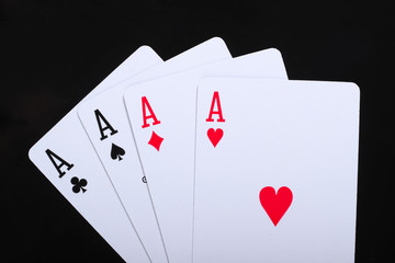 Playing cards of four aces on black background. Game addiction. Poker