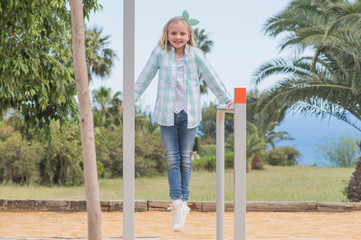 cute beautiful smiling little girl on a playground. Summer time fun